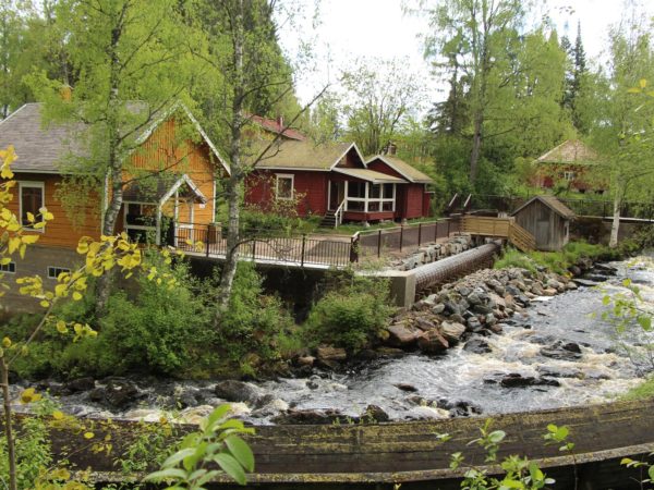 Idylliset puutalot virtaavan kosken rannalla