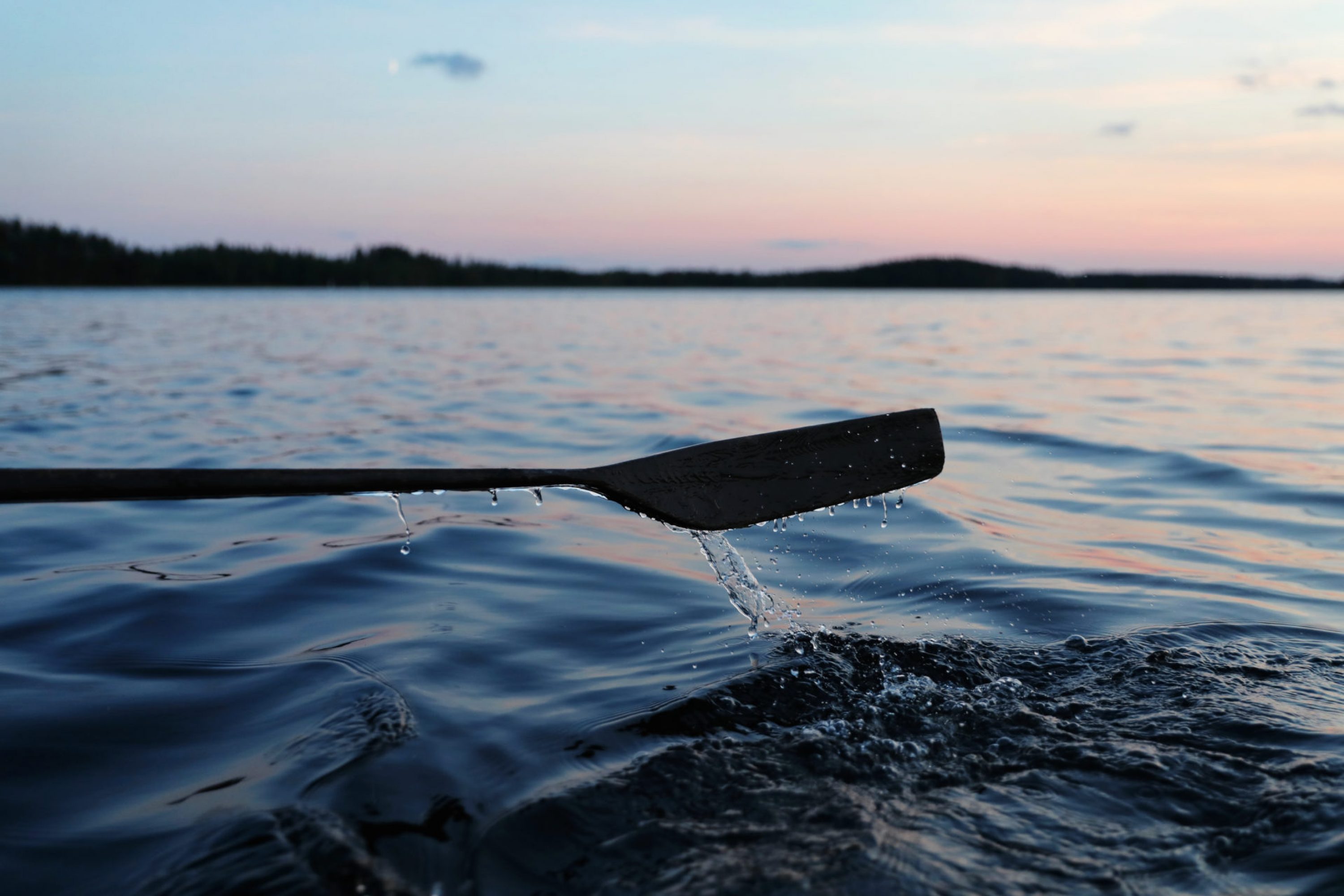 Soutuvene järvellä auringonlaskun aikaan