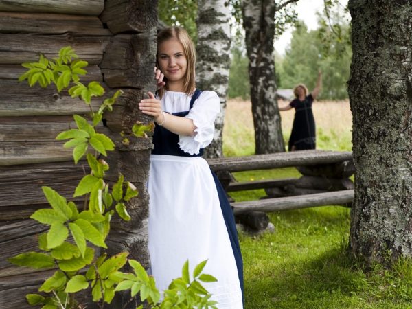 Tyttö fereesissä vanhan hirsimökin kulmalla